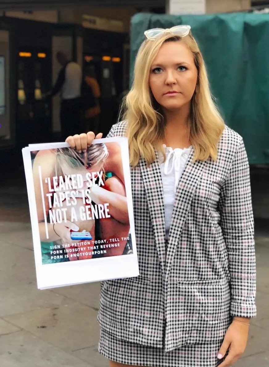 Blonde woman holding a newspaper with an article on revenge porn
